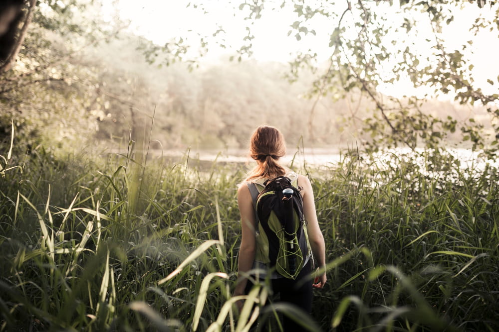 Femme marchant dans la nature verdoyante.
