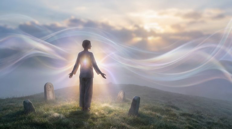 Une personne debout sur une colline au lever du soleil, entourée de volutes de lumière et de pierres anciennes.
